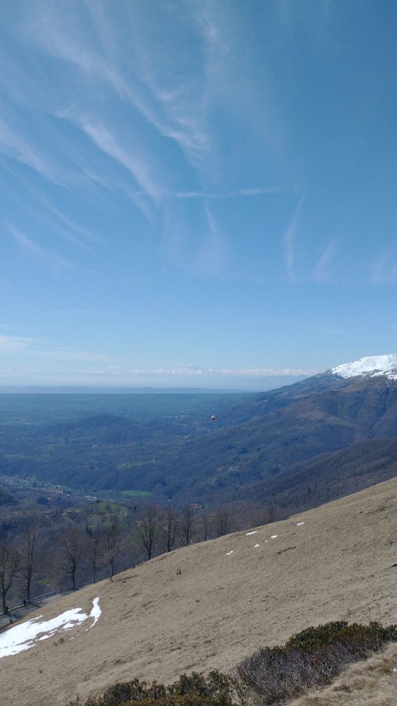 The view facing Southwest from the "Panoramica Zegna" scenic road. The rounded hills in the foreground are those near the city of Biella; beyond those there is an extremely straight hill (called Serra d'Ivrea) and further away another one a bit more irregular (that is the hill on which I live!): these are part of the moraine system surrounding the Ivrea Morainic Amphitheater (the flat region in between cannot be seen in this picture). The Serra d'Ivrea represents also the border between the provinces of Biella and Turin. Far, far away you can see the Westernmost part of the Alpine arc, with a very prominent pyramid-like mountain (located 135 km away in a straight line from the point where I took this photo!) that is Monviso, the highest mountain in the Cottian Alps, reaching an altitude of 3,841 m. It's from the feet of this peak that the Po River, the longest of Italy and the one that has created the vast Po Valley, is born.