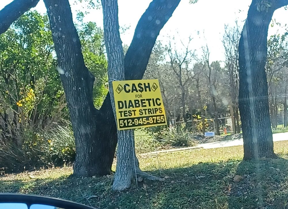 Sign reading "cash for Diabetic Test Strips" with a phone number to call.