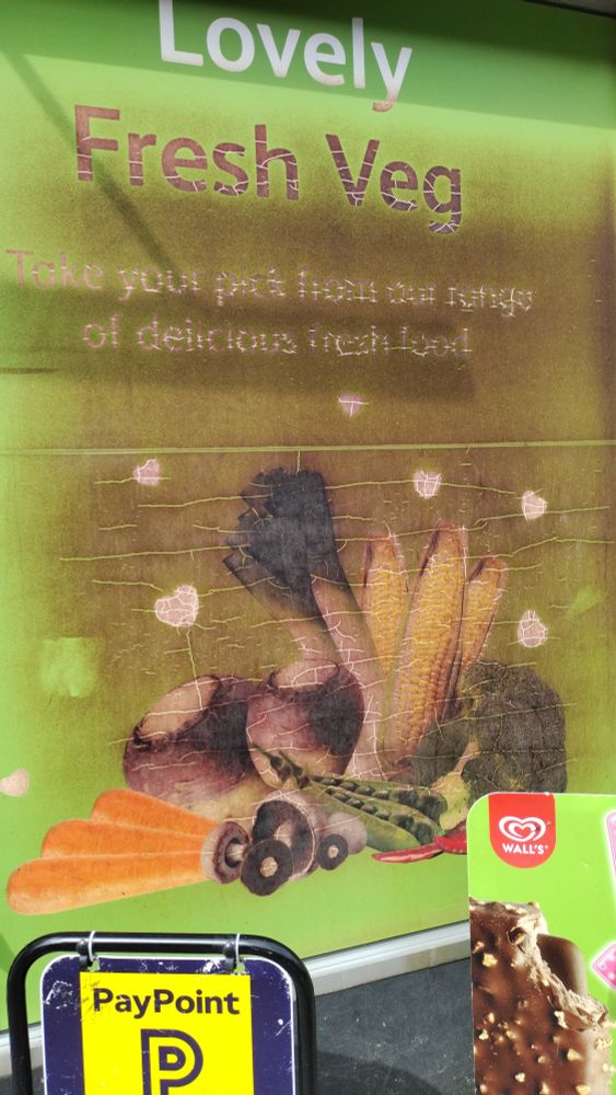 A window advertisement claiming "lovely fresh veg" but its warped and scorched by heat damage, thoroughly browned