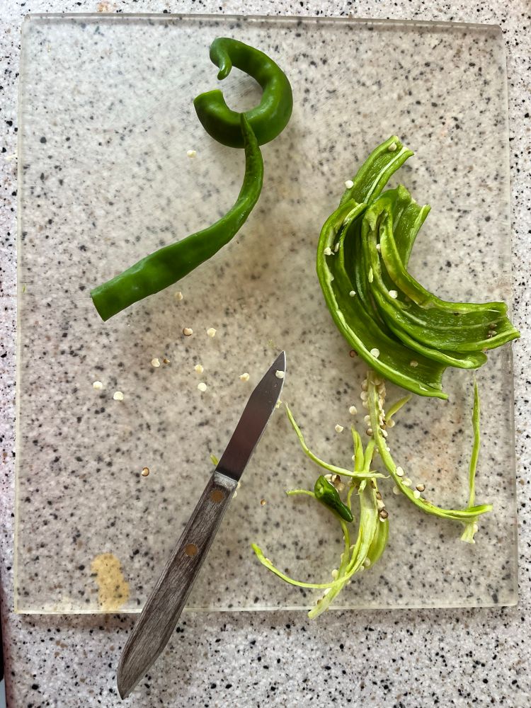 Several hot peppers in the process if being diced for pico de gallo. 