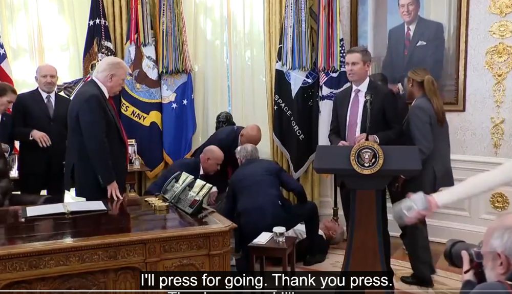 Trump stands by looking on indifferently while one of his flunkies lies on the floor after passing out. 