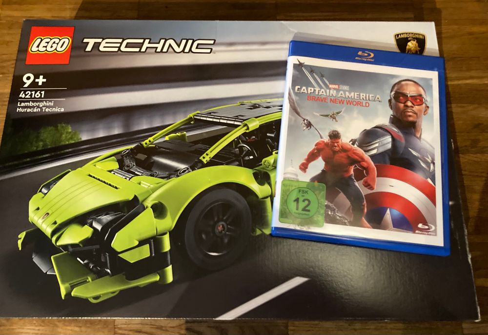 Ein grüner Lambo von Lego. Darauf liegt eine BD von Marvels Captain America "Brave New World". 