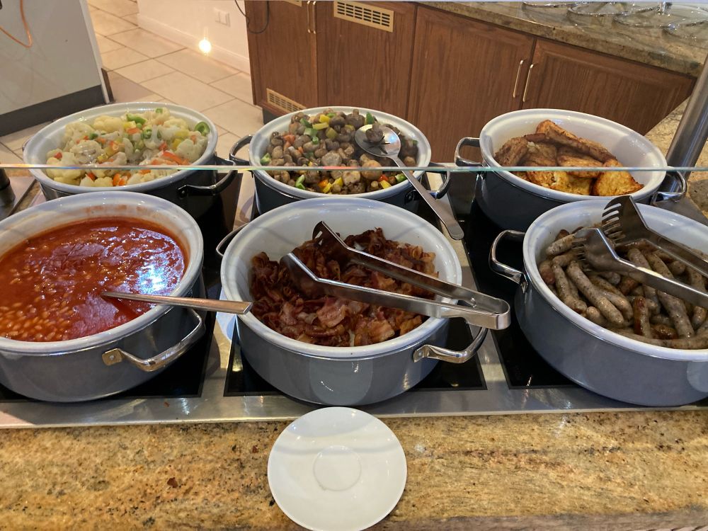 Ein "English-Breakfast" Buffett. Mit Bohnen, Bacon, Blumenkohl, Champignons, Röstis und Frankfurter Würstchen. 