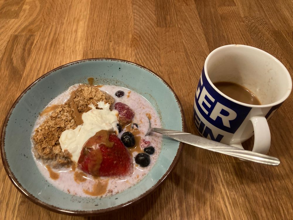 HSV Tasse mit Kaffee und ein Teller mit Weetabix in Joghurt, Milch und Beeren. 