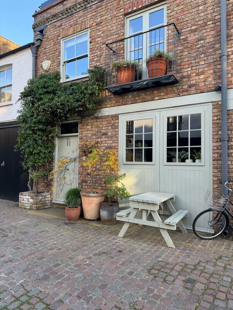 Brick building with vines and a white picnic table