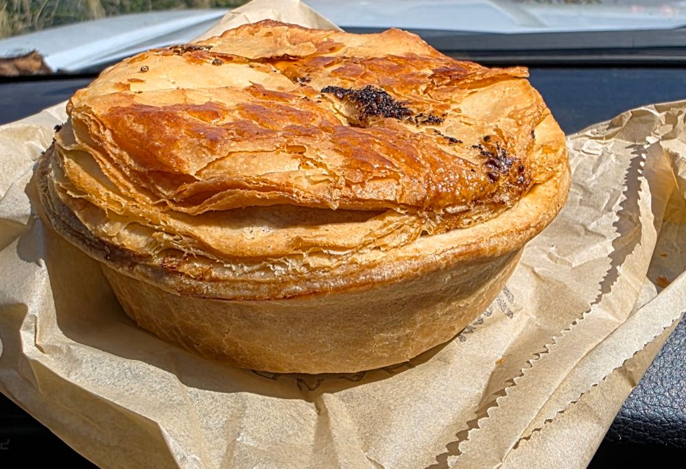 Flaky, savory pie on a paper bag.