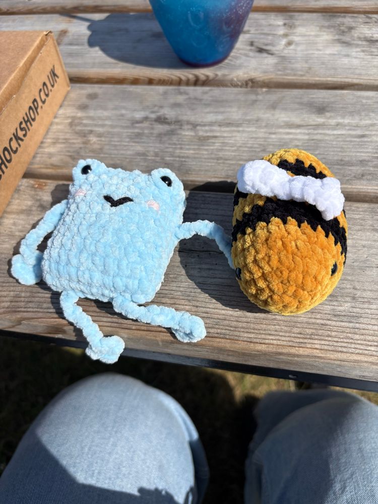 crochet plushies of a bee and a blue creature