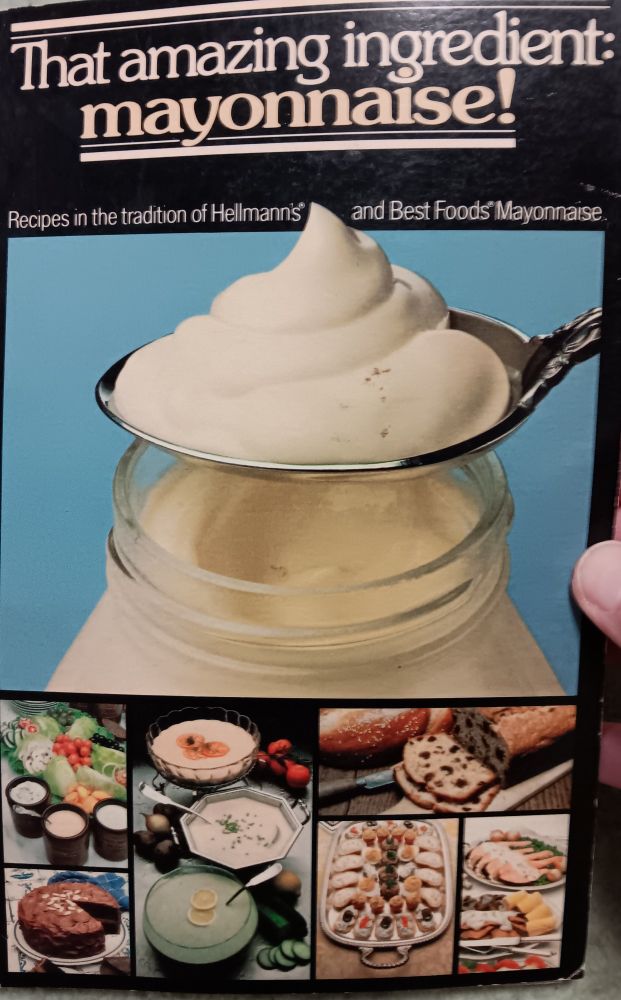 1980s cookbook titled "That amazing ingredient: mayonnaise!" with the subtitle "Recipes in the tradition of Hellmans' and Best Foods' Mayonnaise". The largest picture on the cover collage is a heaping tablespoon of mayo; below that are six photos of various unappealing dishes that look like they escaped from 1970s Weight Watchers recipe cards