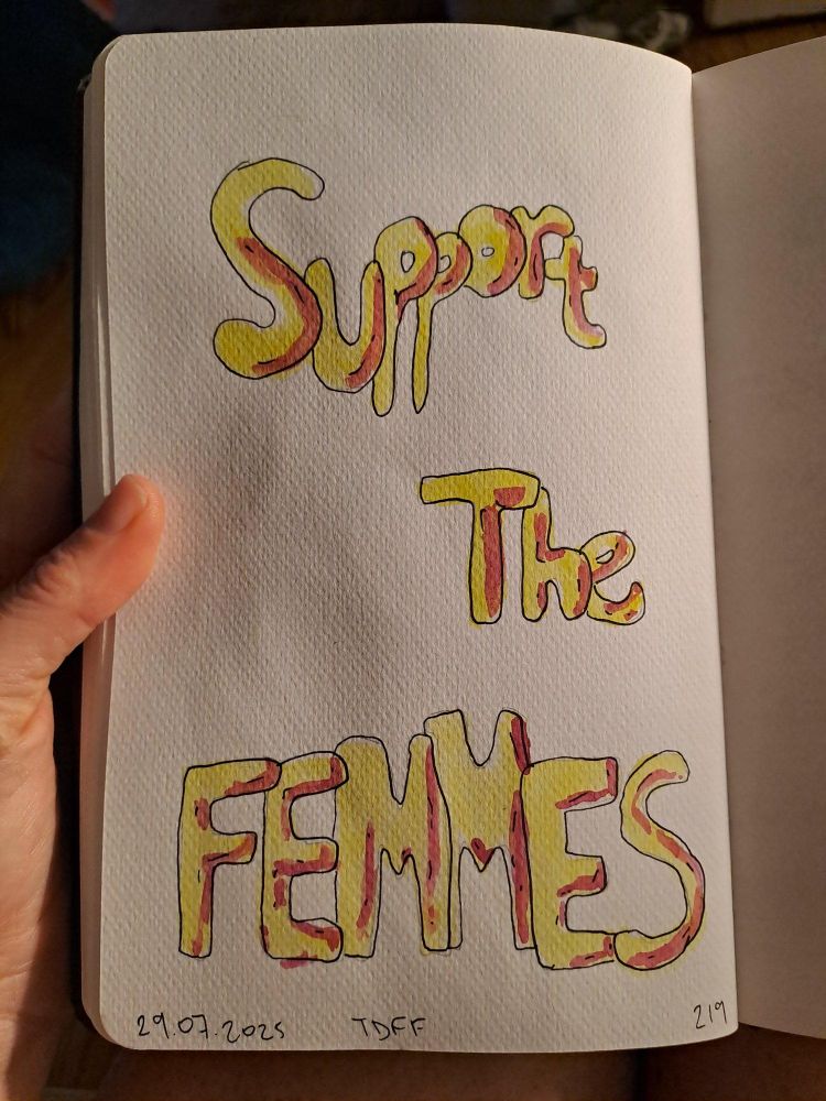 A watercolour sign with "Support the Femmes" in yellow bubbly writing with pink highlights