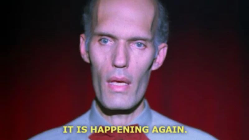 captioned screenshot of The Fireman/The Giant from Twin Peaks on stage when he tells Dale Cooper "It Is Happening Again."