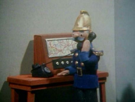 Captain Flack answers the Trumpton fire station switchboard telephone.