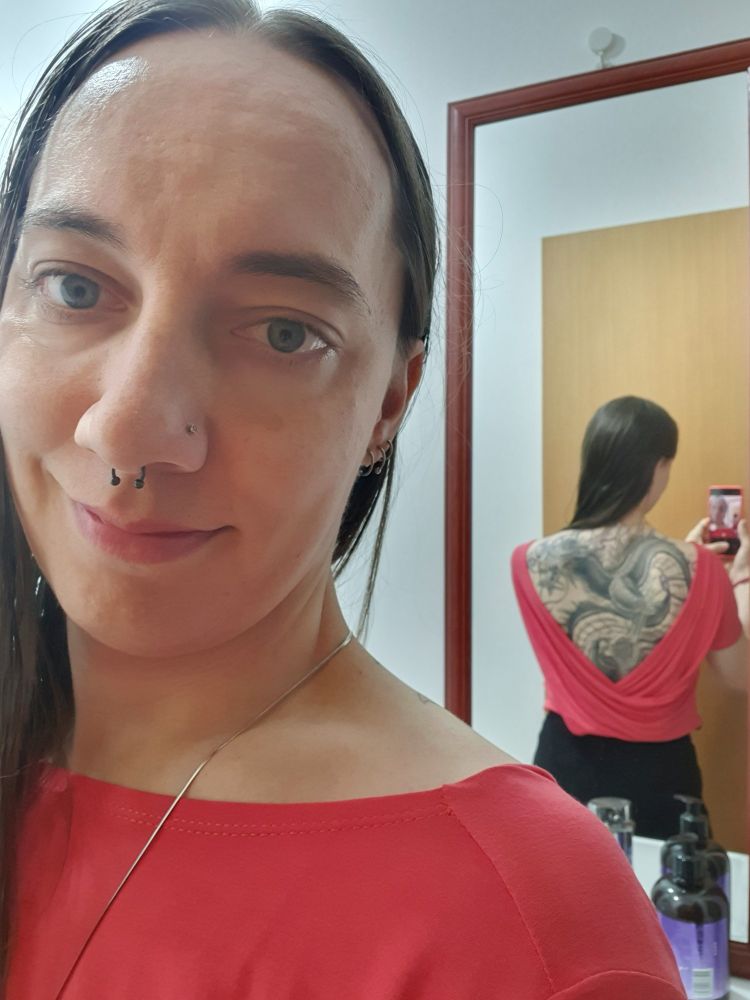 Selfie no espelho para mostrar a tatuagem de dragão nas costas. 