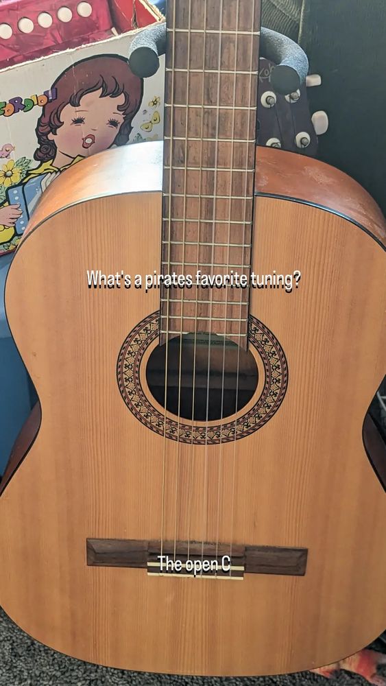 A nylon string guitar with the joke "What's a pirate's favorite tuning?" - "The open C"
