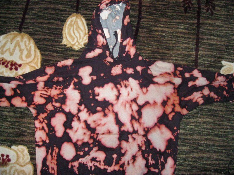 A black hoodie bleached with splotches that look like melted film