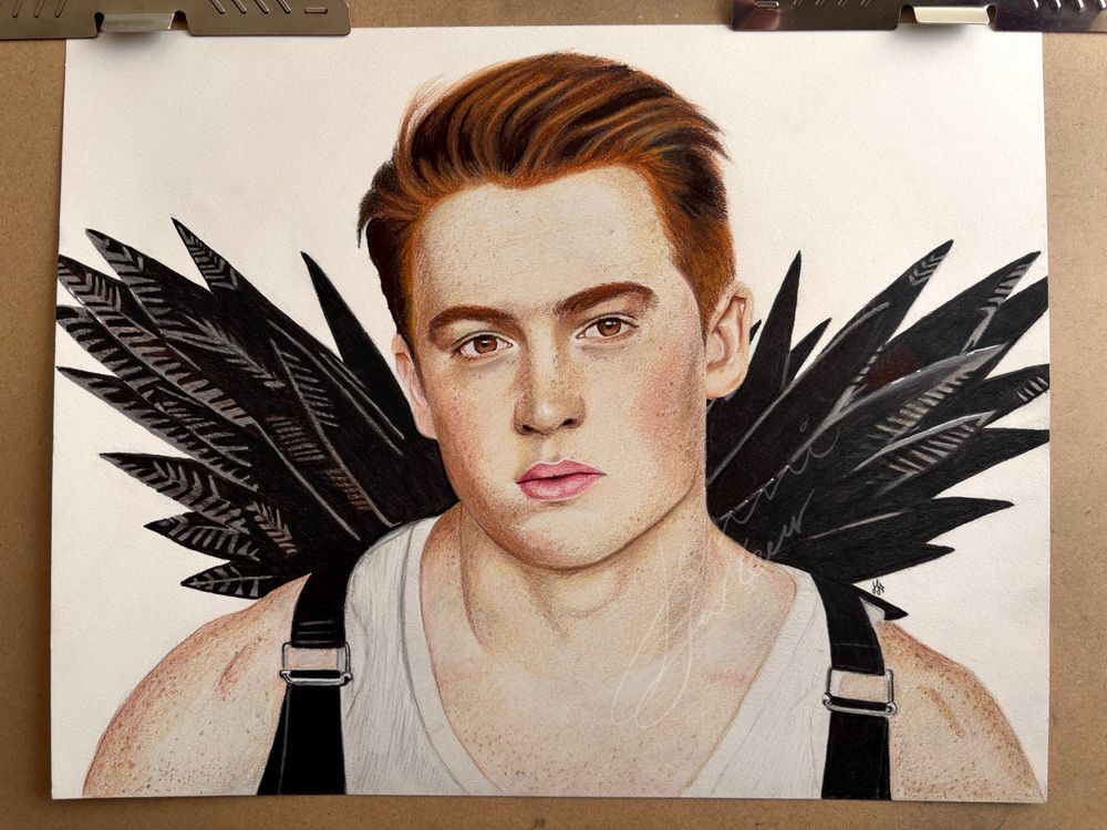 A coloured pencil drawing of Kit Connor in a white tank top and black and brown feather wings with black straps. 