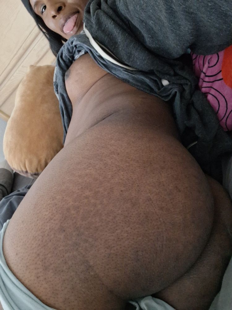 Rizzky cheekily smiling with their tongue out while showing their ass and tit's from behind for the camera 