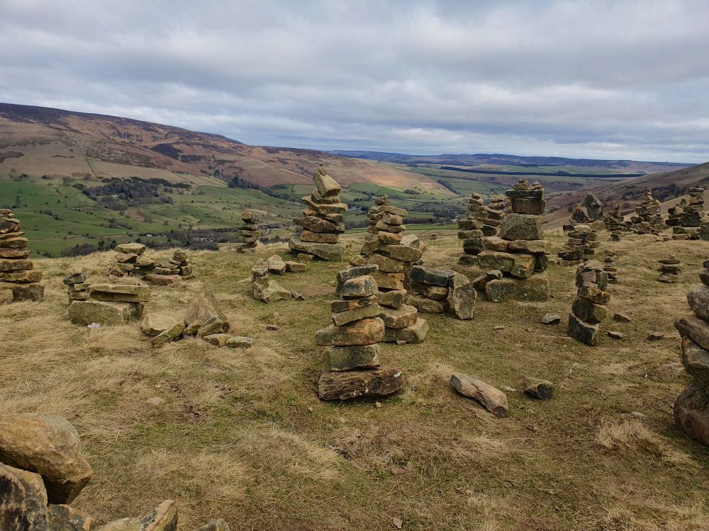 Multiple stacks of stones atop a hill 