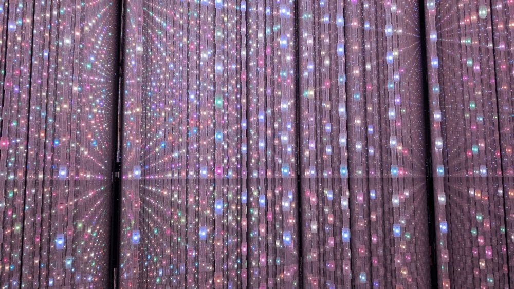 The Infinite Crystal Universe exhibit. Hundreds of light points are used to make three dimensional spaces. The color and tone of the lights is controlled by visitors using an app. 