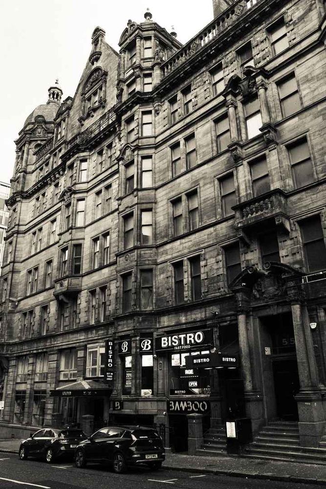 Sepia photo of a front of elaborate old buildings.