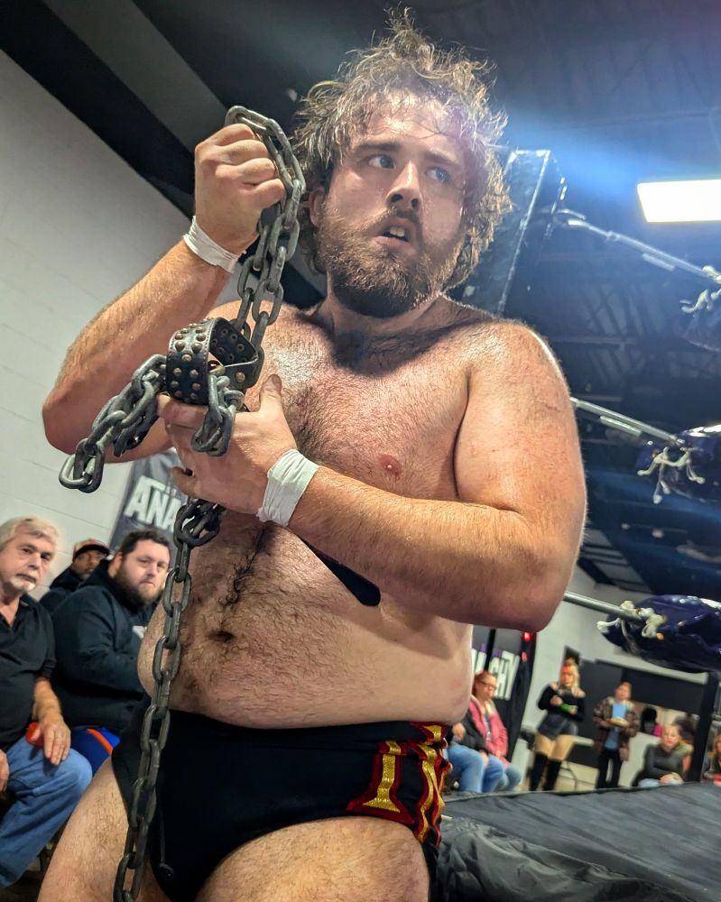 Mad Dog Connelly holding a chain dog collar, looking ready to use it.