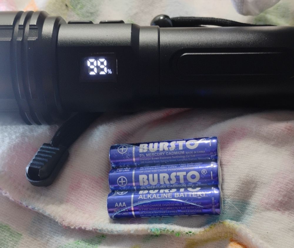 Batteries labelled Bursto next to a flashlight. 
