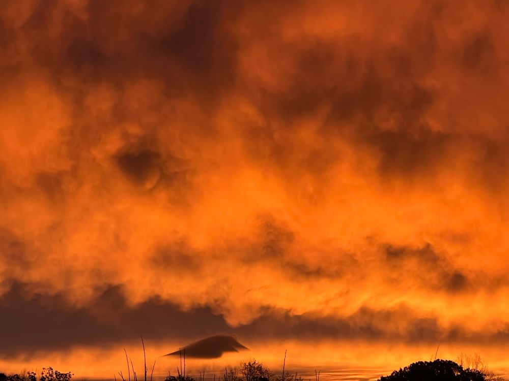 Picture of a sunrise with dramatic cloud formation in orange tones.