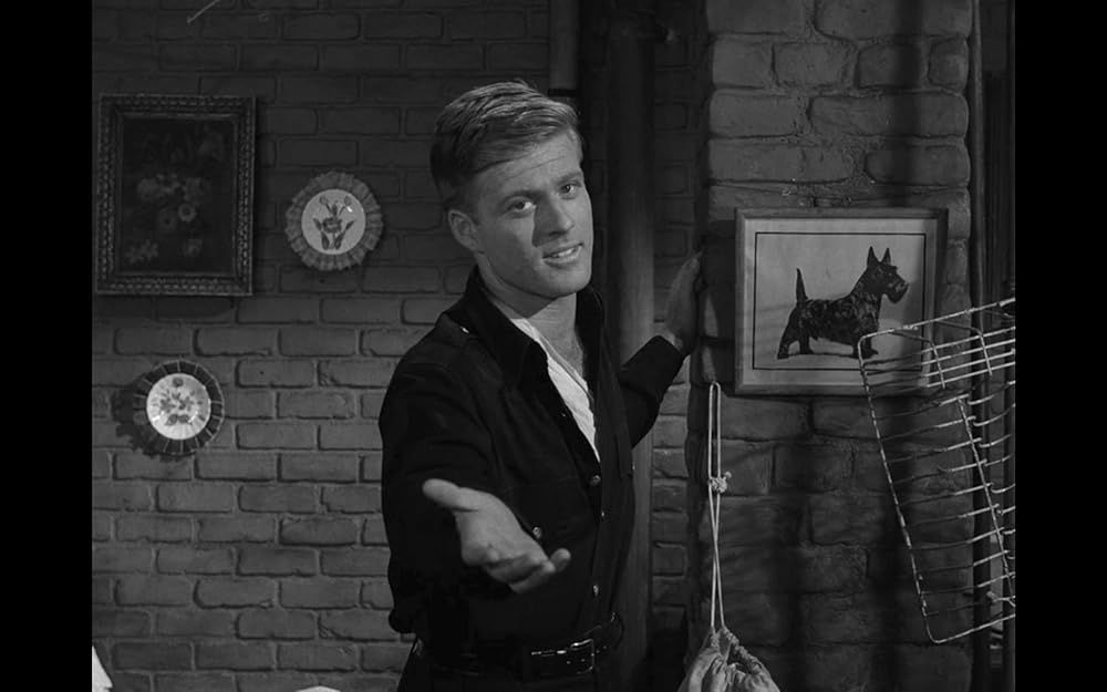 A still of Robert Redford from THE TWILIGHT ZONE's third season episode "Nothing in the Dark." A youthful Redford offers his hand out to the camera.