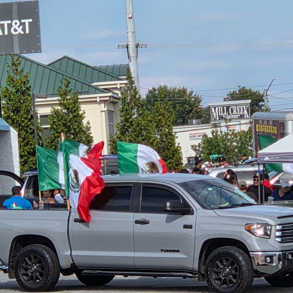 Trucks and Mexican flags at gathering in shopping center 