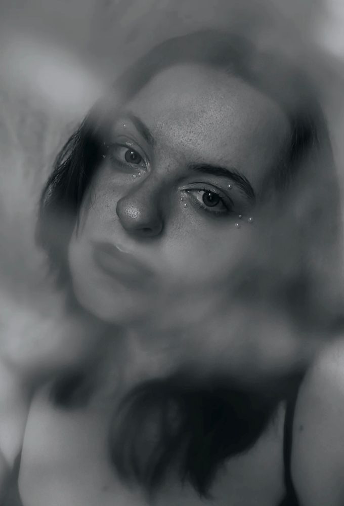Ein Portrait von einer jungen Frau (mir), dir Perlen um die Augen geklebt hat, Drumherum ist es leicht verschwommen und das Bild ist in schwarz/weiß.