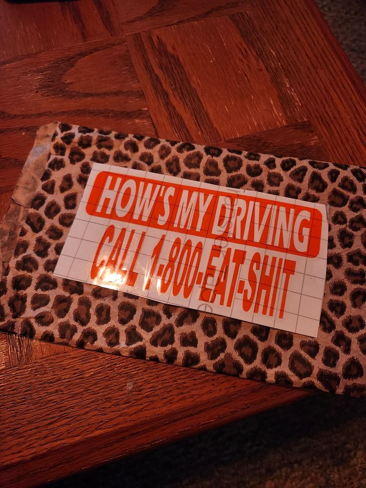 Decal that says "how's my driving? Call 1-800-EAT-SHIT"