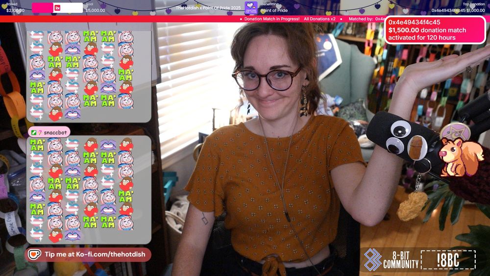Screenshot from TheHotdish's stream. Woman in a pony tail, with big ol' glasses and a smirk(??) holds her hand up to a notification with text: "0x4e49434f4c45: $1500 donation match activated for 120 hours."

In chat there are a load of hearts with the trans pride flag colors.