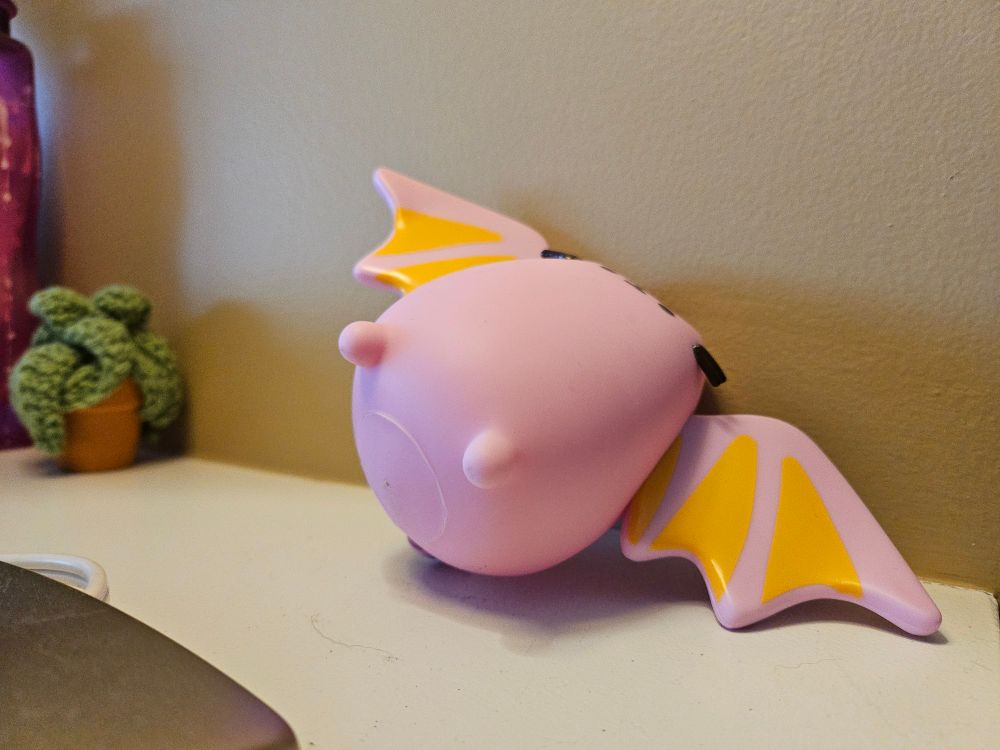 a light purple vinyl pusheen bat figurine having trouble standing up due to its irregular shape