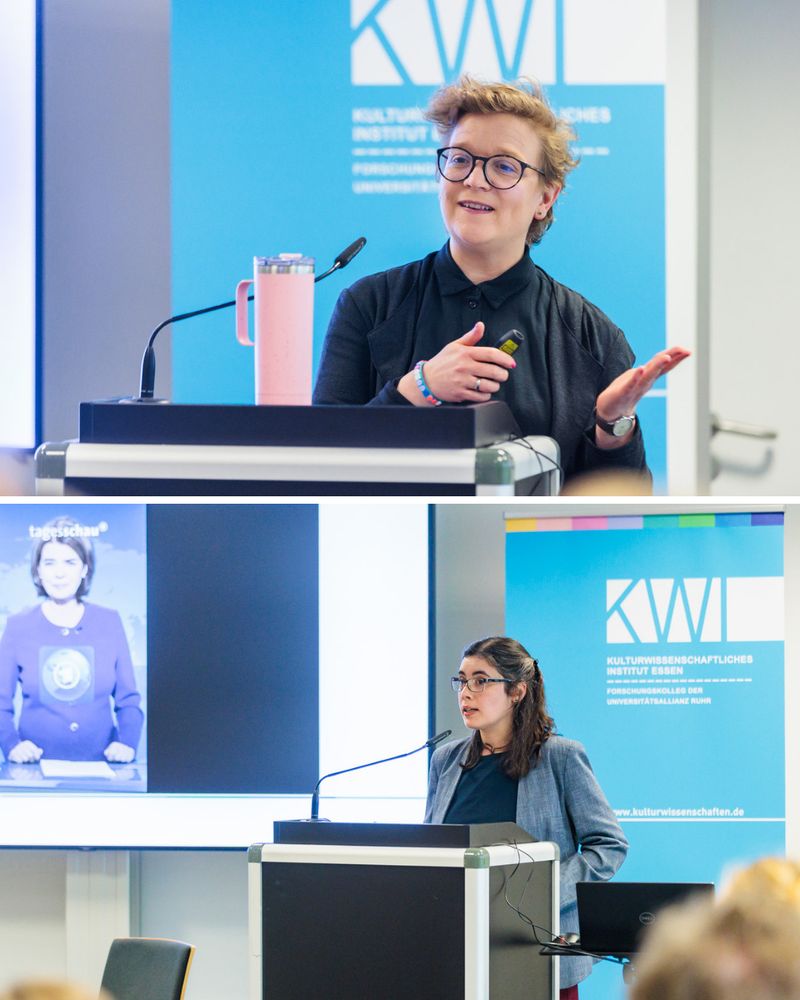 Zwei Vortragende am Rednerpult. Eine Person spricht mit Mikrofon und Gestik, im Hintergrund ist eine „Tagesschau“-Nachrichtensprecherin auf dem Bildschirm zu sehen. Das KWI-Logo ist ebenfalls zu erkennen.

