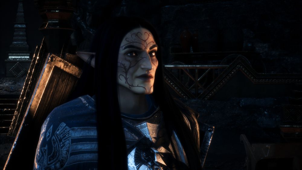 a male elf with long dark hair wears a thoughtful facial expression as he listens to the consequences of saving one city over another, he wears grey warden armor in a dimly lit outdoor area in minrathous, tevinter imperium 
