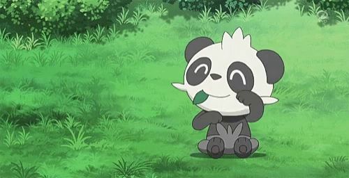 a panda bear is eating a green leaf in a field .