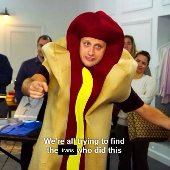 Guy from “I think you should leave”, wearing a hotdog costume. Popular meme.

He usually says “We’re all trying to find the guy who did this” 

I changed “guy” to “trans”