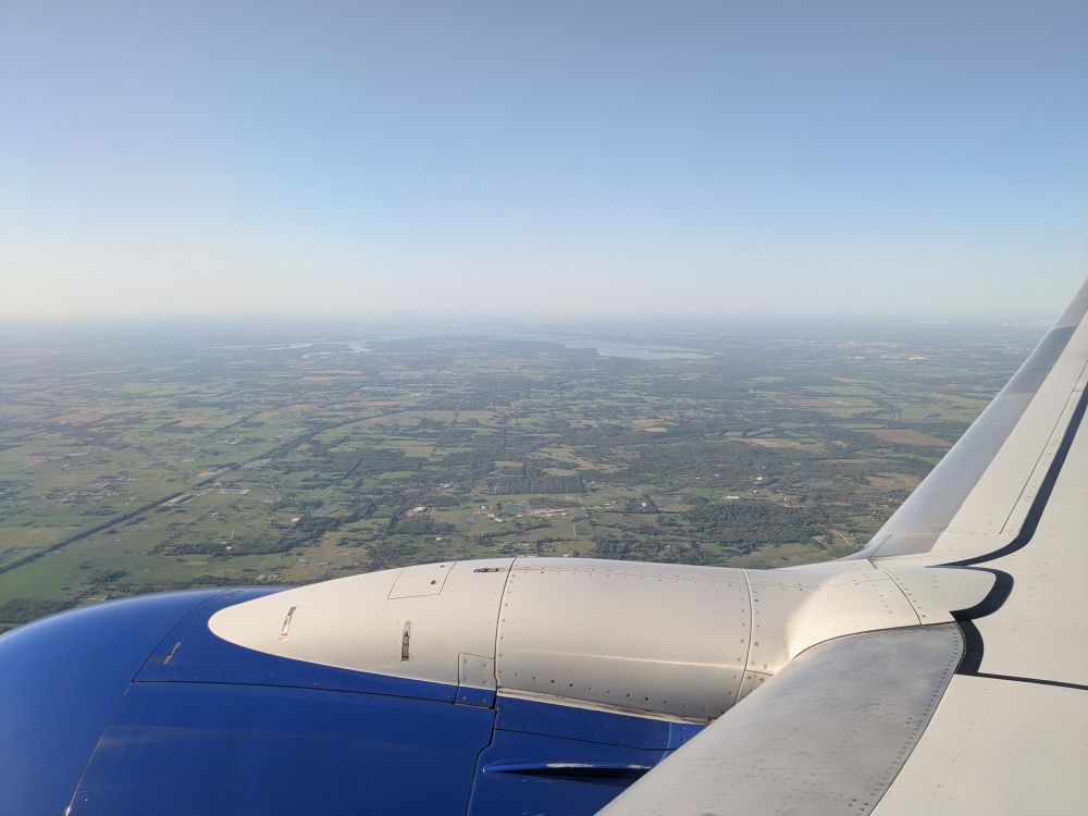 View from inside of an airplane descending in Dallas. The flaps are in use.