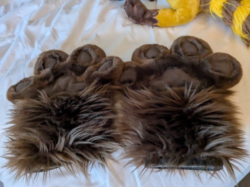 Faux fur paws with four fingers each, all brown.
