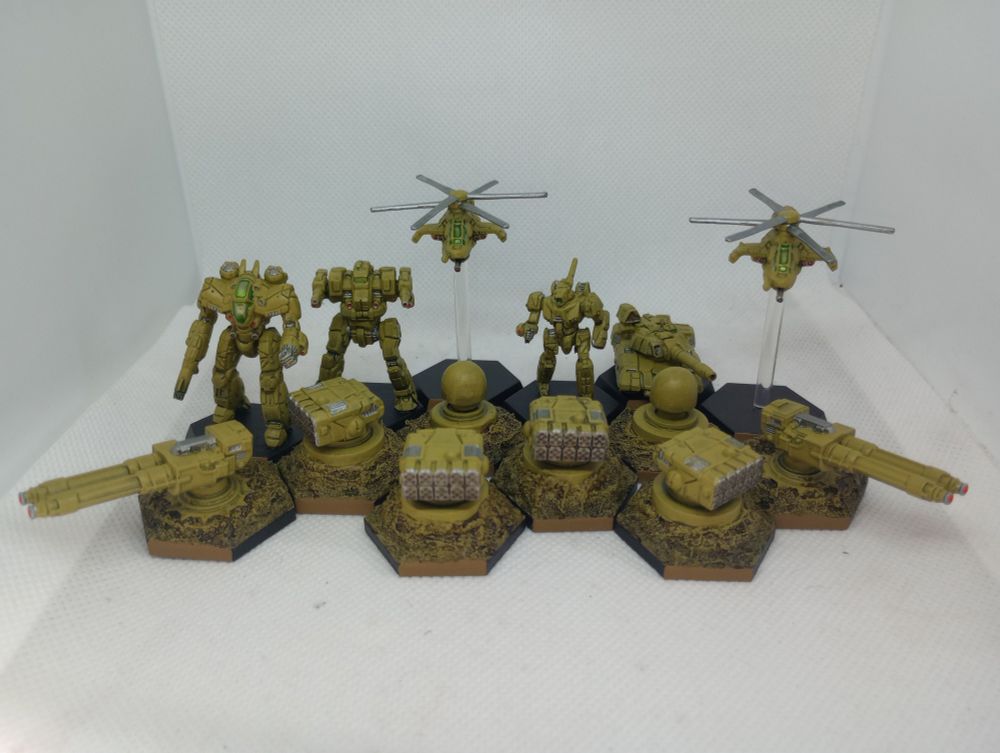 A collection of 4 missile turrets, 2 twin heavy laser turrets, 2 radar domes, 2 attack  helicopters, 1 tank, and 3 battlemechs all in a dull mustard yellow 