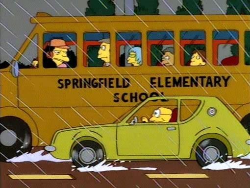 Frame from the Simpsons, where Hans Moleman is driving a green AMC Gremlin al9ngside the Springfield Elementary School Bus.