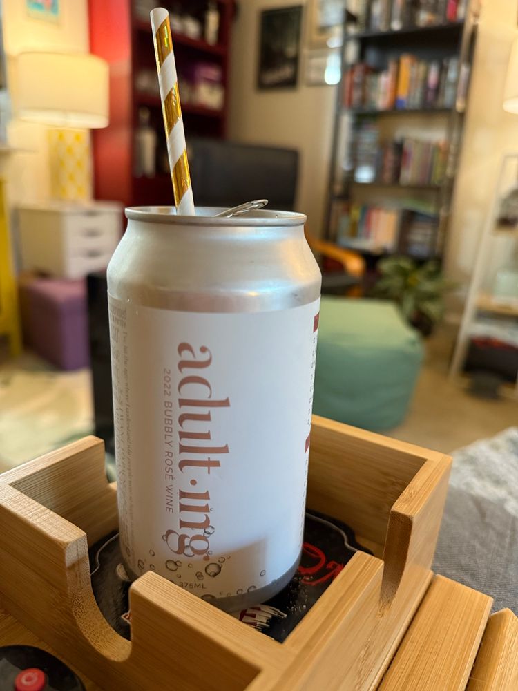 A close up of a can of bubbly rose wine. The wine label is Adulting.
