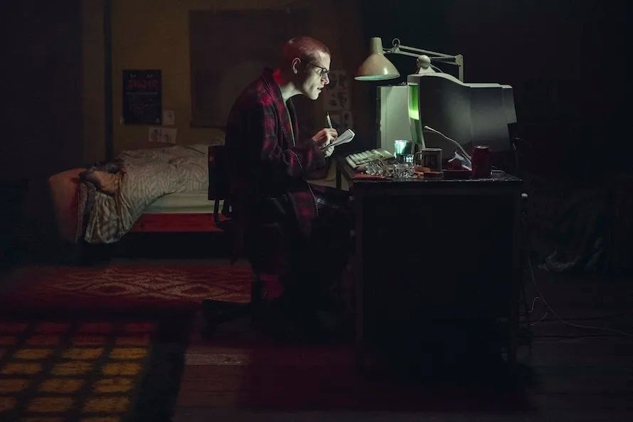 brit dweeb in a dark room hunching over his 90's computer setup with obsessive concentration