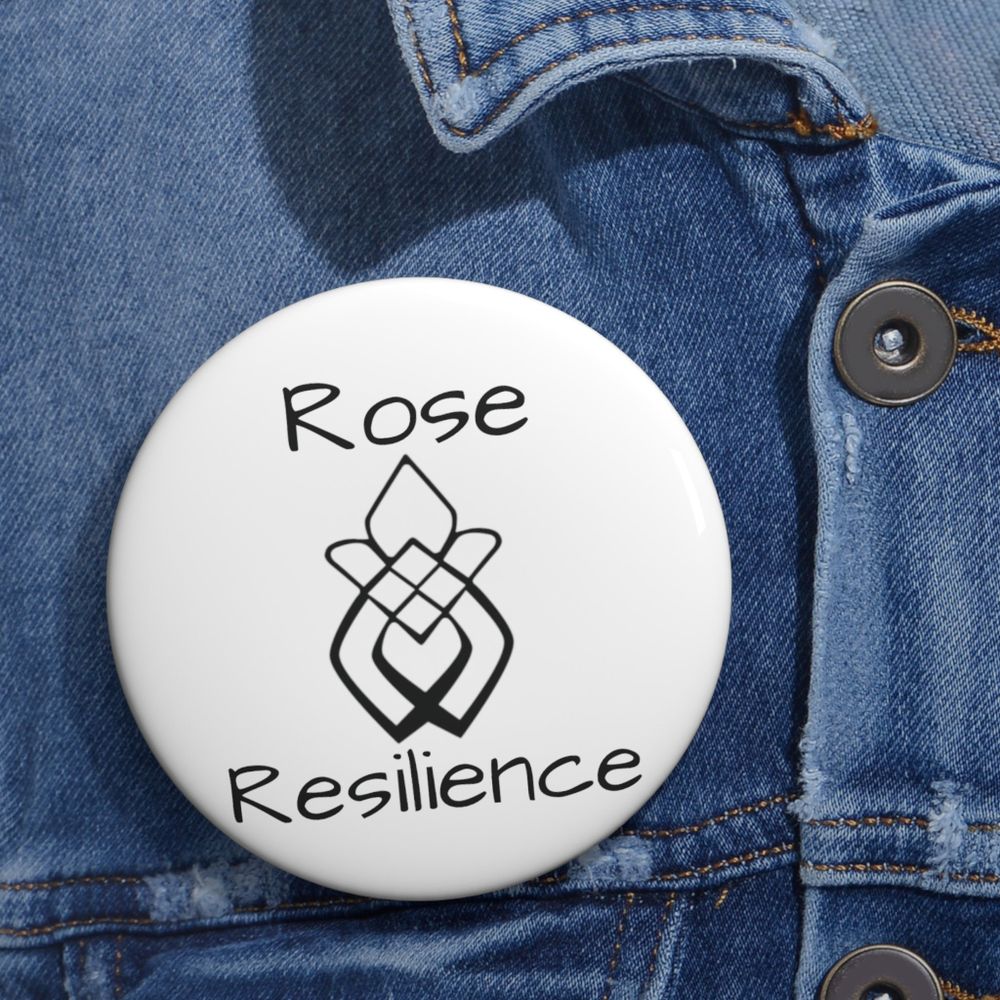 **ALT Description:** A close-up of a white round button pin on a denim jacket. The pin features the words "Rose" and "Resilience" in a stylized font above and below a design that combines a rose and an infinity symbol, emphasizing themes of strength and empowerment. The button is prominently displayed, showcasing its significance as a symbol of survival and fortitude.https://stingscustom.etsy.com/listing/1695132465