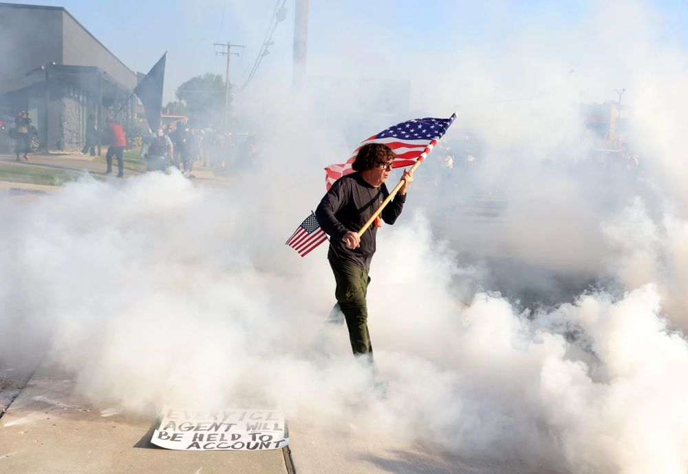 Veteran carrying USA flag through teargas lobbed by terrified ICE goons 