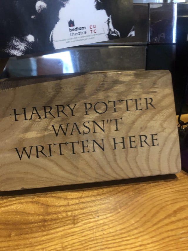 A wooden sign on a cafe shelf, inscribed with ‘HARRY POTTER WASN'T
WRITTEN HERE’