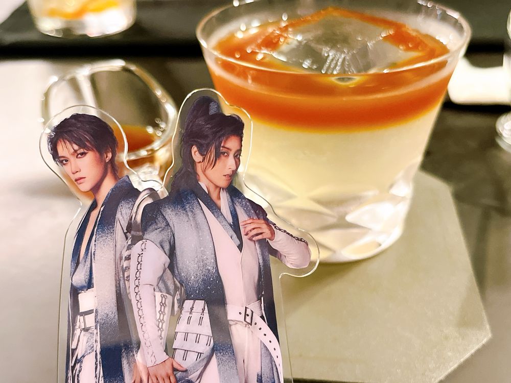 コーヒーチェリーを使ったおいしいノンアルコールカクテル。手前には『HiGH&LOW THE 戦国』のキャラクター、姫川弦流と神洲崎湧水のアクリルスタンドが写っている。