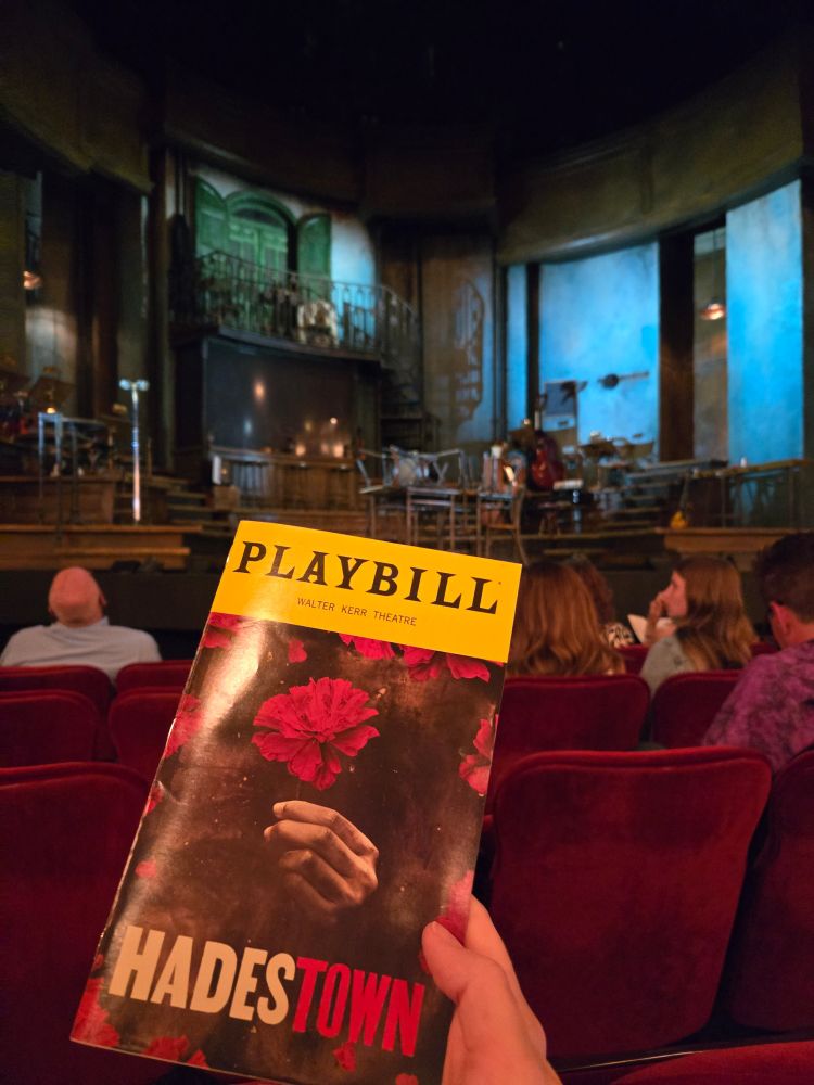 Holding up my Hadestown playbill in front of the stage from my *excellent* center-orchestra seat.