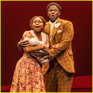 Production photo from "Ragtime," with two black actors, Joshua Henry and Nichelle Lewis, embracing while facing forward and singing their faces off at the climax of "Wheels of a Dream." Lewis is holding a prop infant, swaddled in blankets, so all the audience sees is a baby-shaped object.