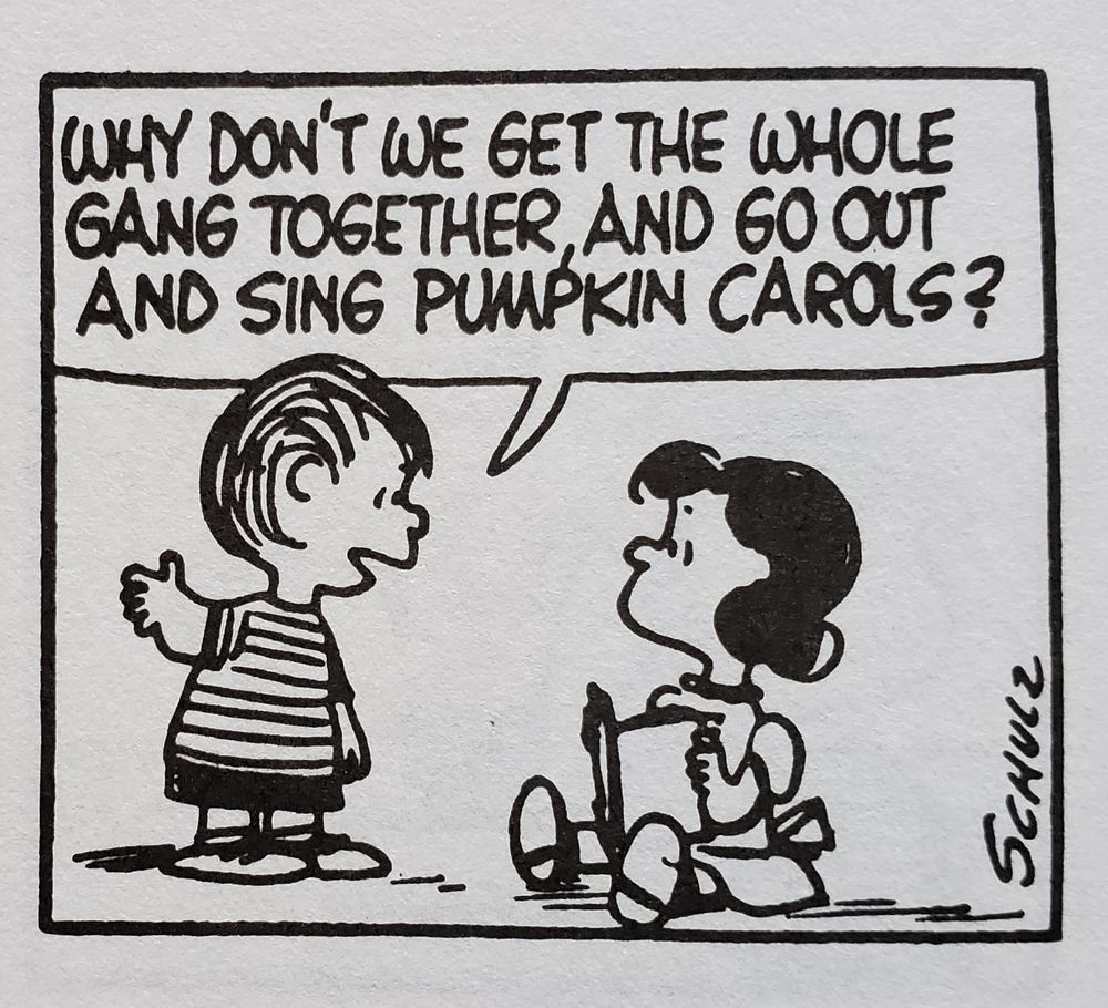 A panel from a black-and-white Peanuts strip, in which Linus, standing, is saying to Lucy, who is sitting on the ground reading a book: "Why don't we get the whole gang together, and go out and sing pumpkin carols?"
