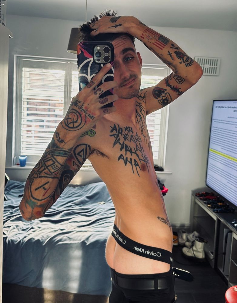 Twink wearing a jockstrap looking into a mirror